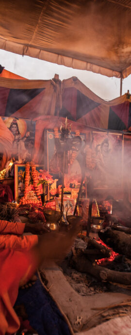 Sadhu smoking around camp fire during Kumbh Mela 2013